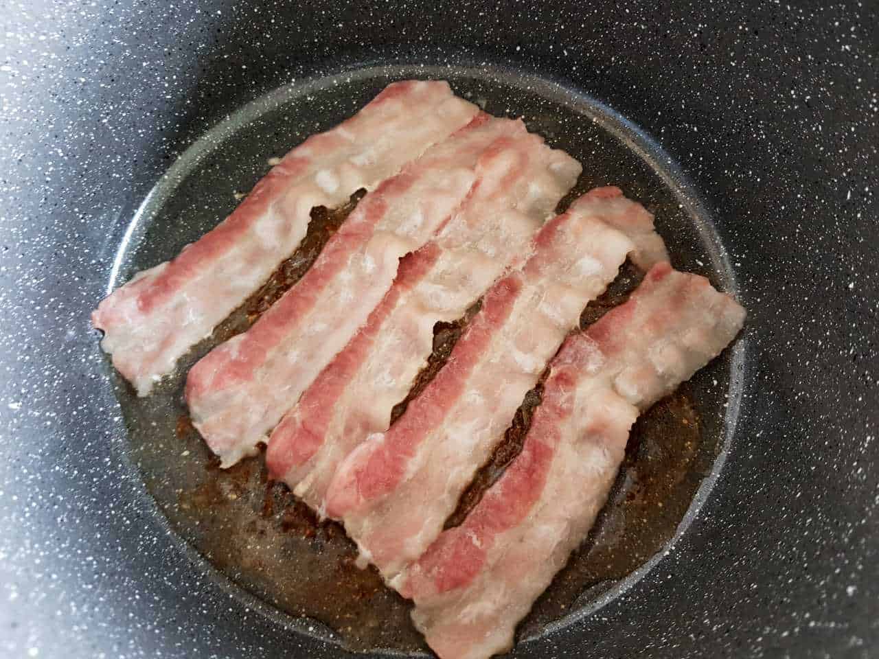 Bacon cooking in a pot.