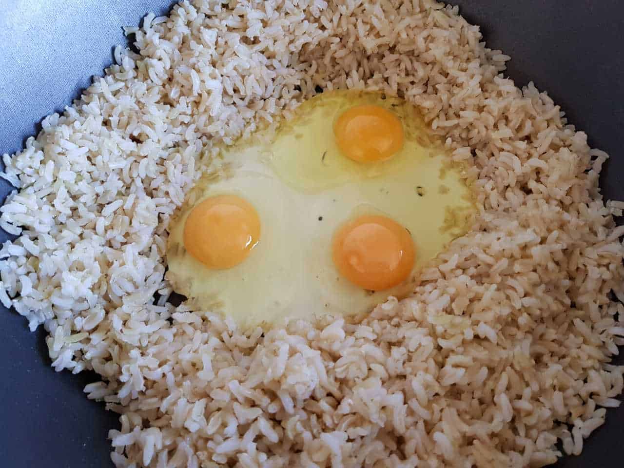 Brown rice an eggs in wok.