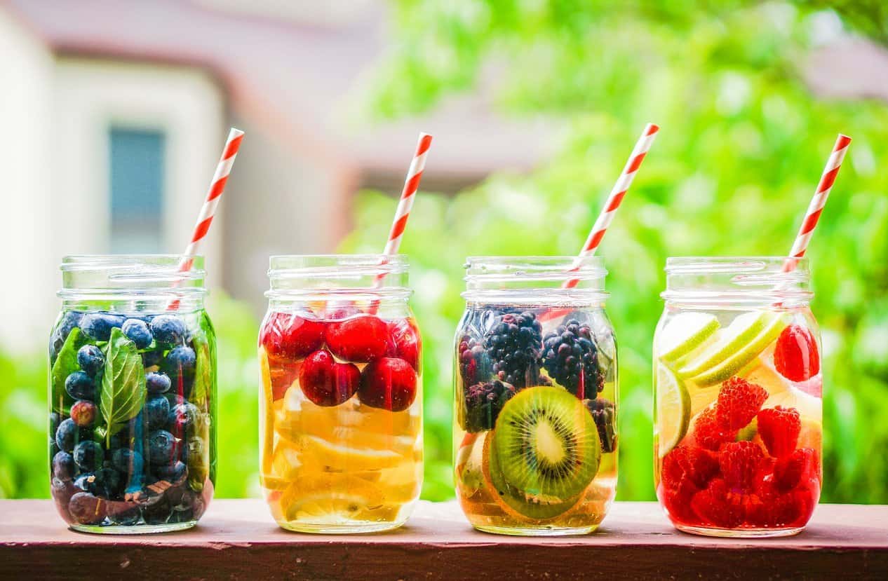 Mason jars with water, fresh fruit and straws.