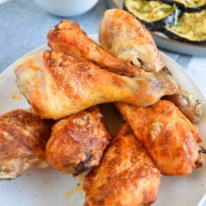 Air fried buffalo chicken legs stacked on a plate.