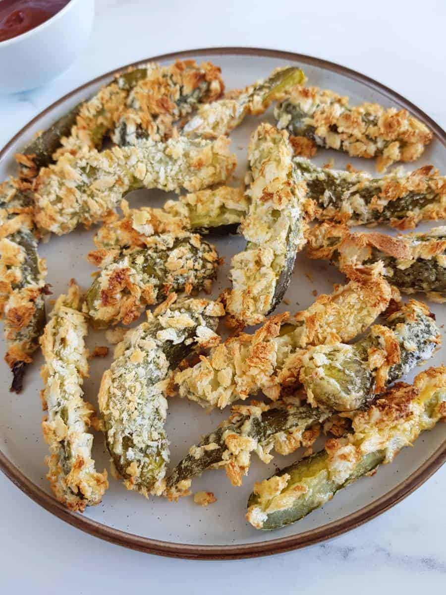 Air fried breaded pickles on a plate.