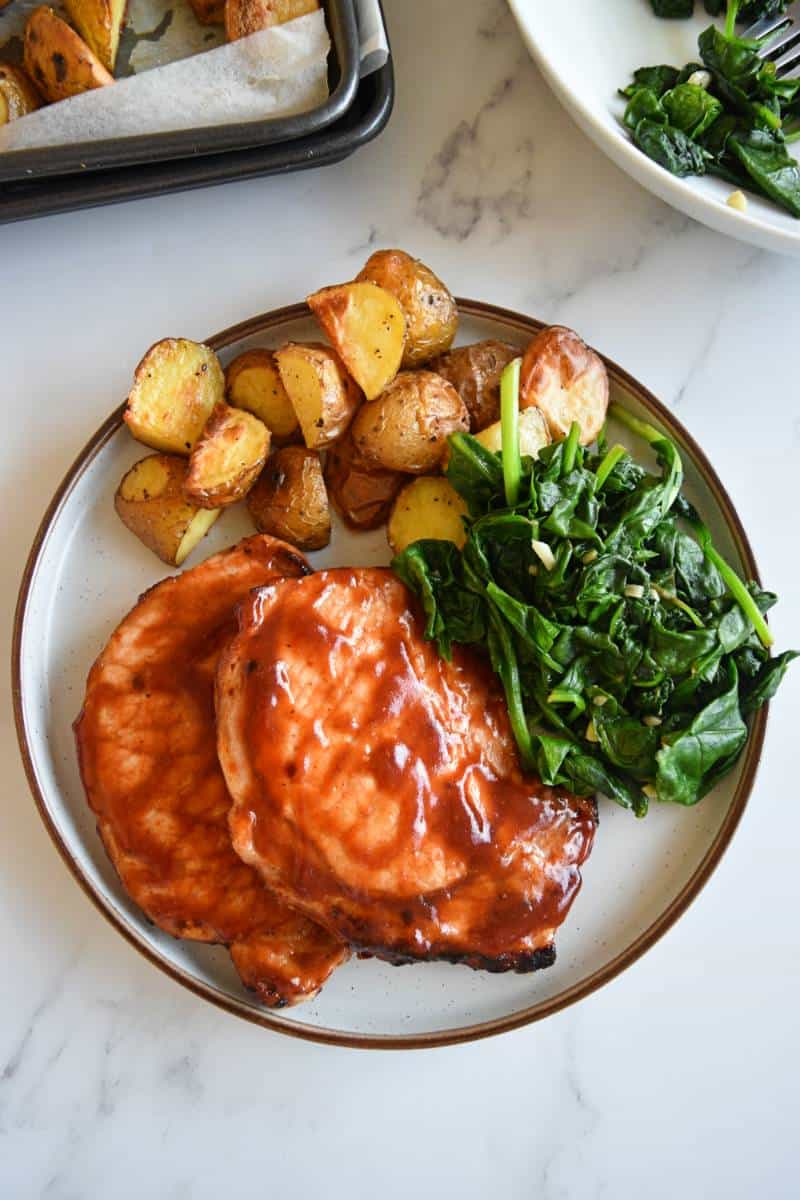 BBQ pork chops with greens and potatoes.