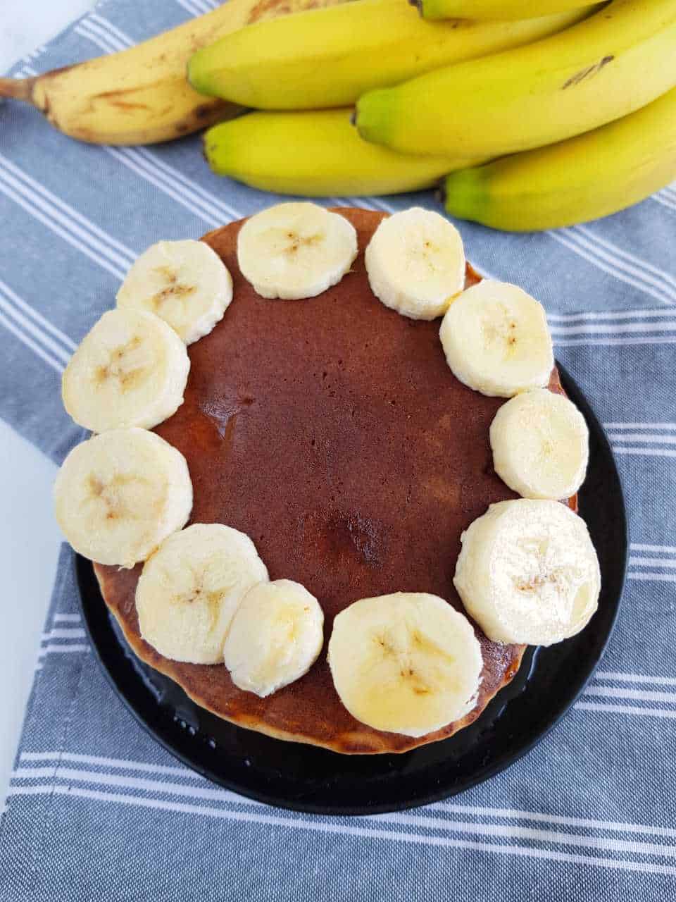 Whole wheat banana pancakes with bananas on top.