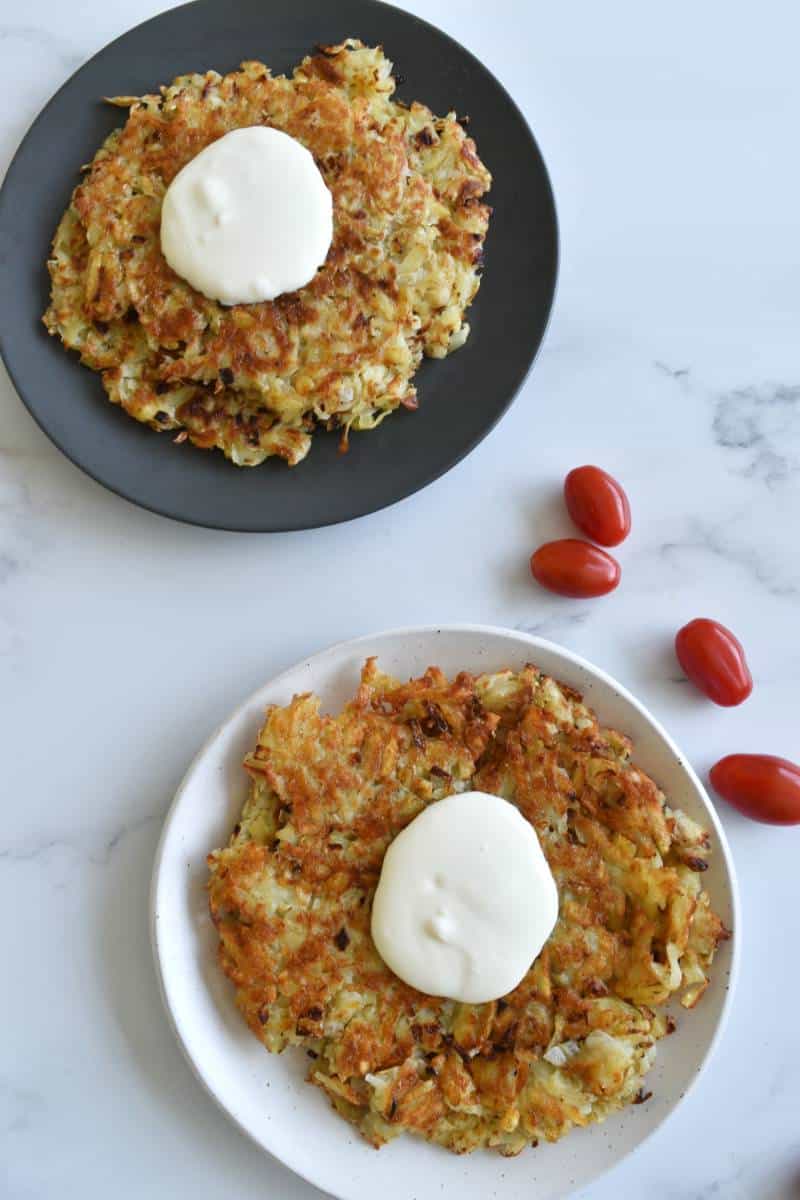 Belarus Draniki on plates topped with sour cream.