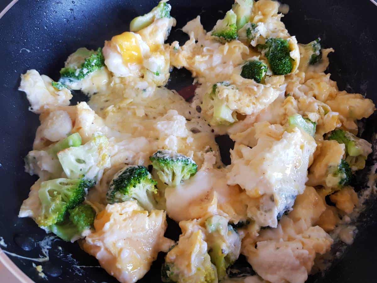 Broccoli scrambled eggs in a pan.