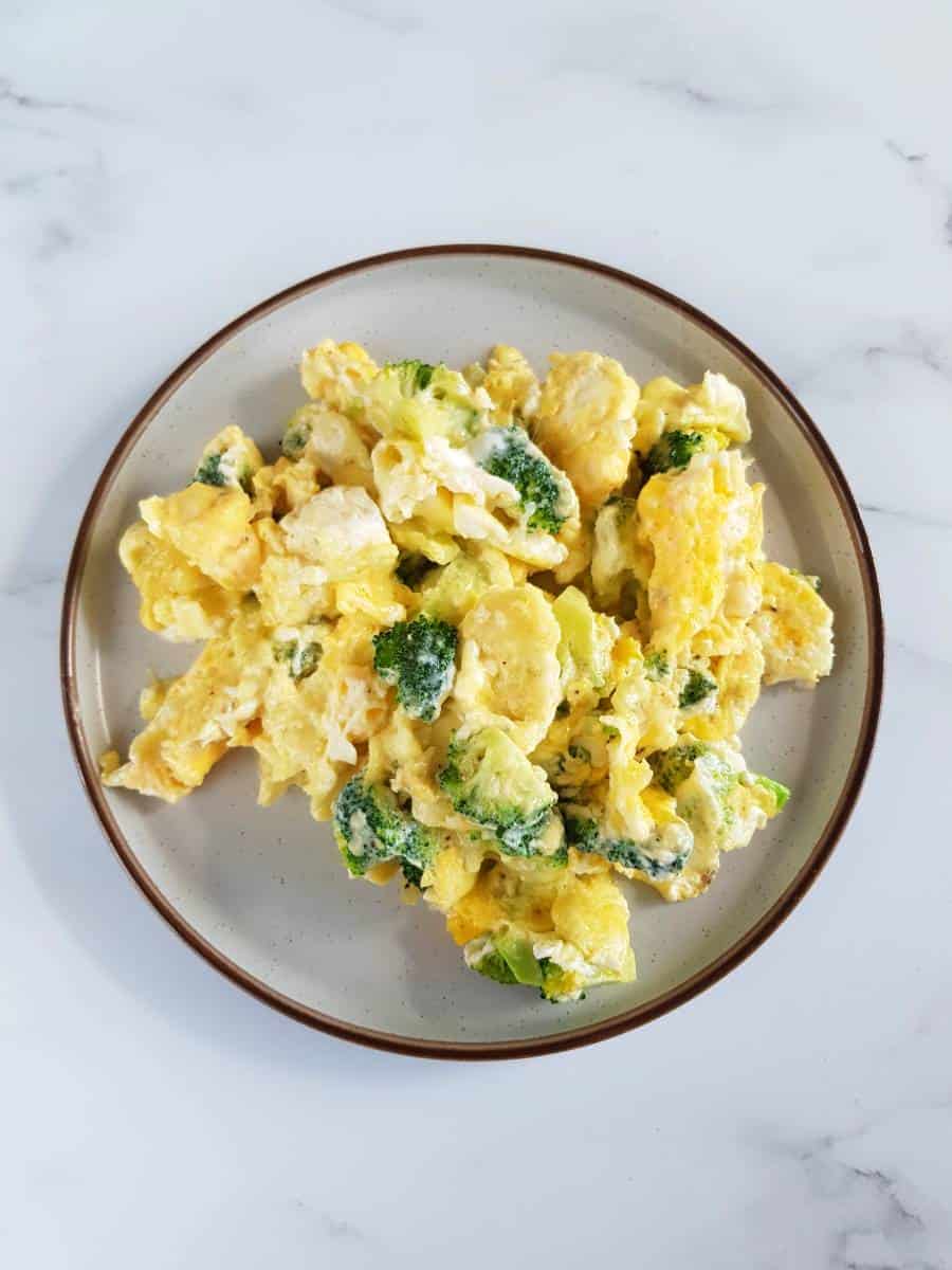 Broccoli scrambled eggs on a plate.