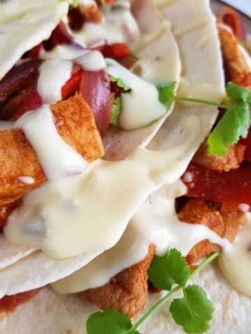 Cheesy tex mex sour cream sauce on fajitas.