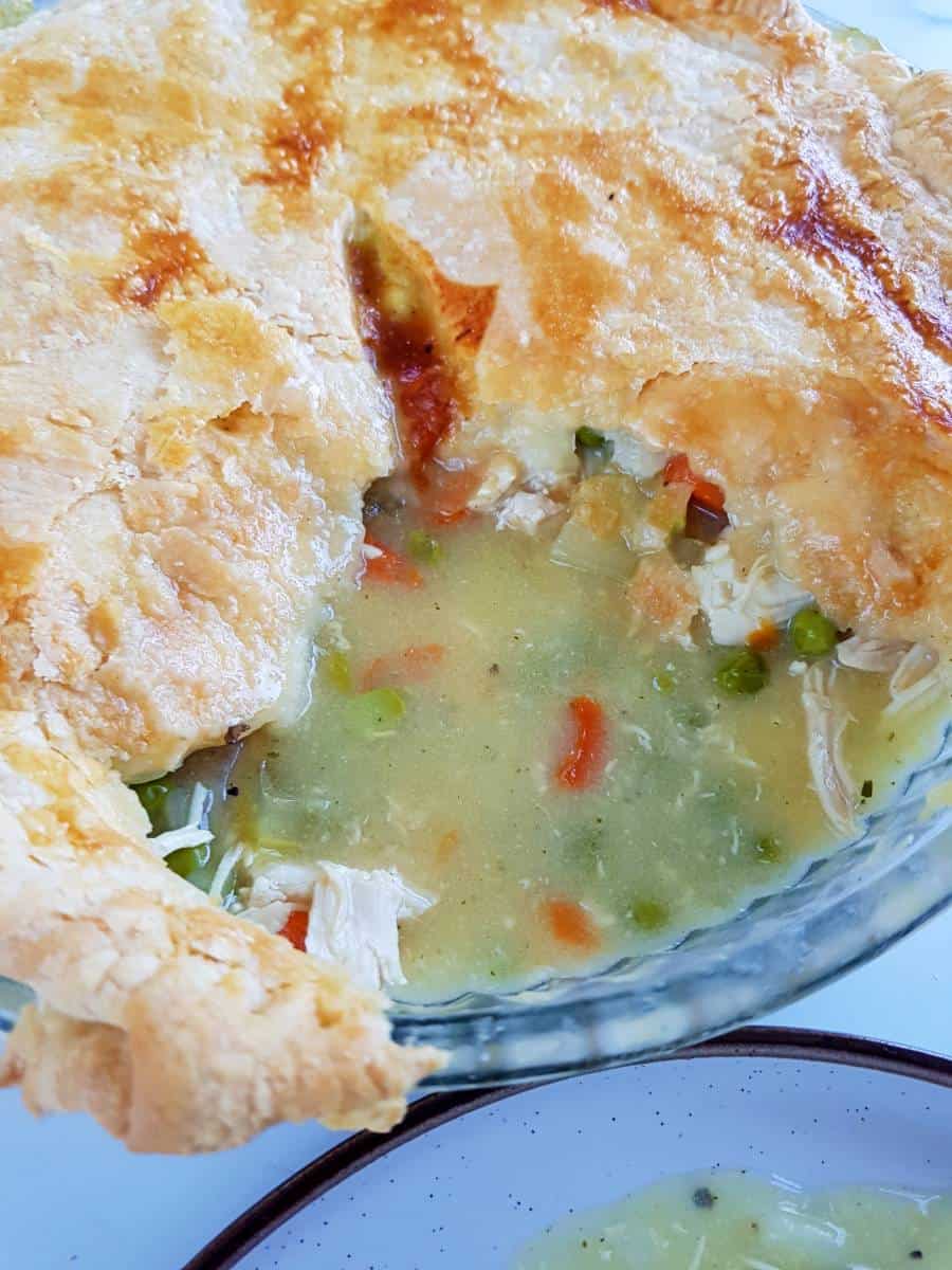 Chicken pot pie with almond milk and a slice cut out.