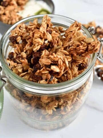 Granola with cinnamon and raisins in a mason jar.