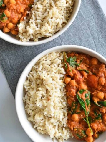 Curry with hummus and chickpeas and spinach in a bowl with rice.