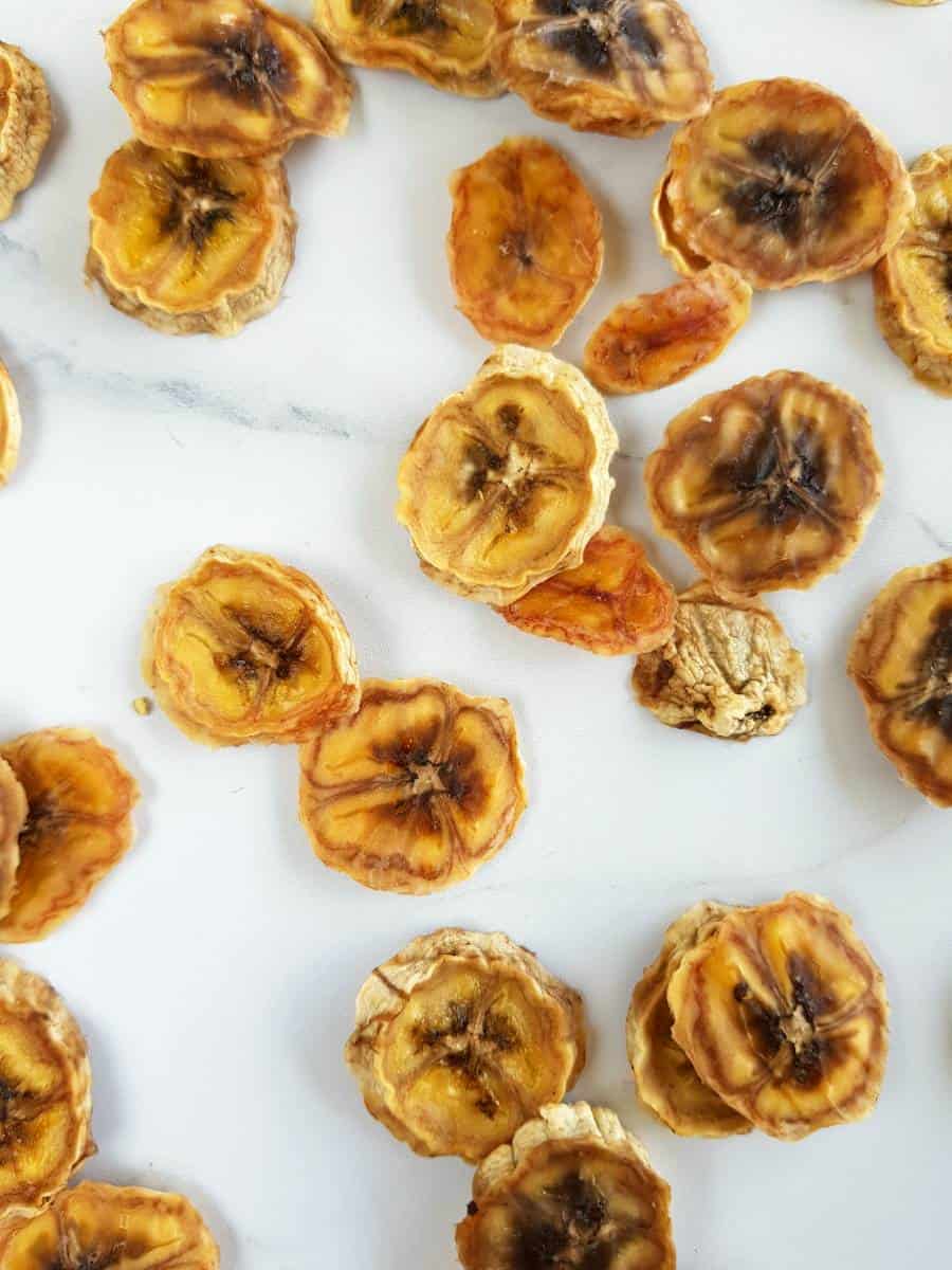 Dried banana slices on a marble table.