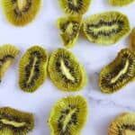Dried kiwi slices on a marble table.
