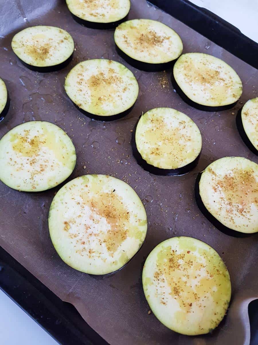 Eggplant slices on a baking tray.