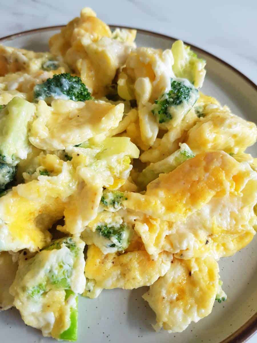 Cheesy eggs and broccoli on a plate.