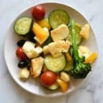 Halloumi stir fry on a white plate on a marble table.