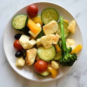 Halloumi stir fry on a white plate on a marble table.