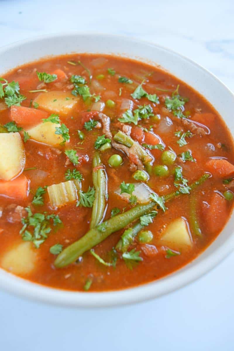 Hamburger vegetable soup in a white bowl.