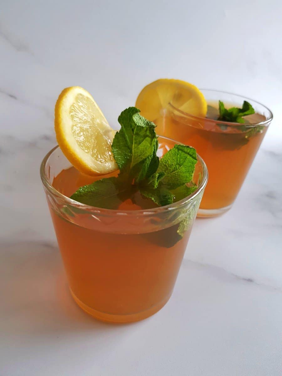 Iced tea in glasses with fresh mint and lemon slices.
