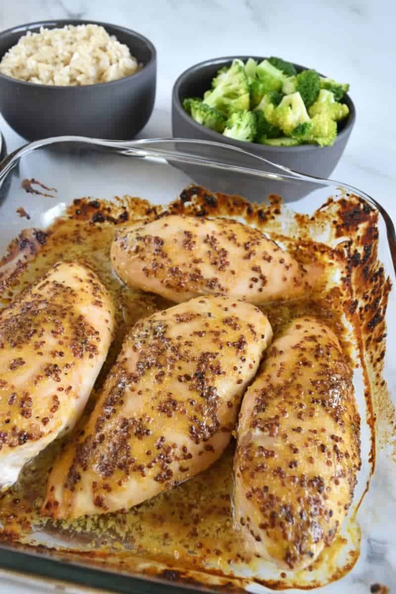 Mustard and honey chicken breasts in a casserole dish.