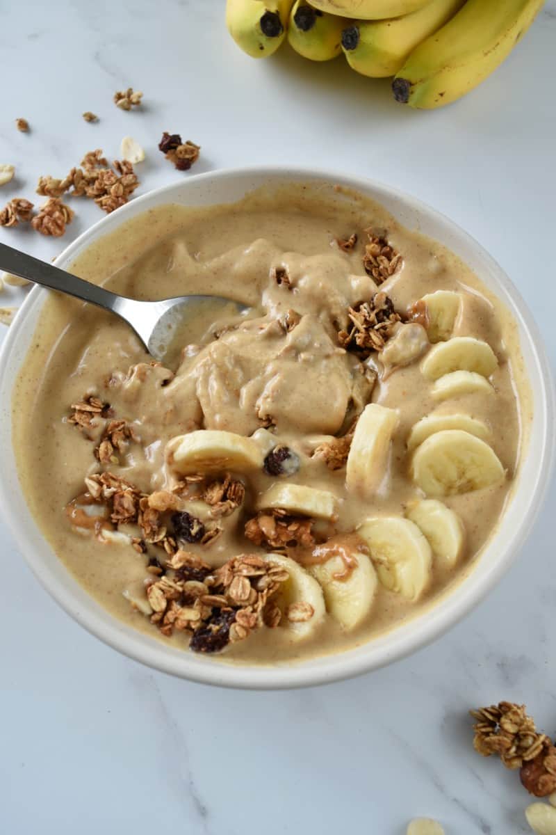 Peanut butter smoothie blended in a bowl with granola.