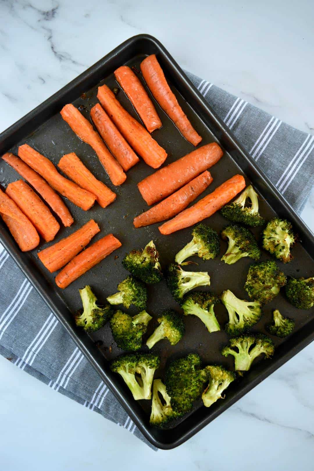 Roasted broccoli and carrots on a sheet pan.