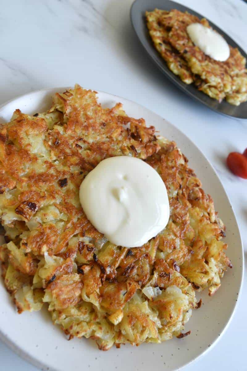 Russian potato pancakes on a plate on a marble table.