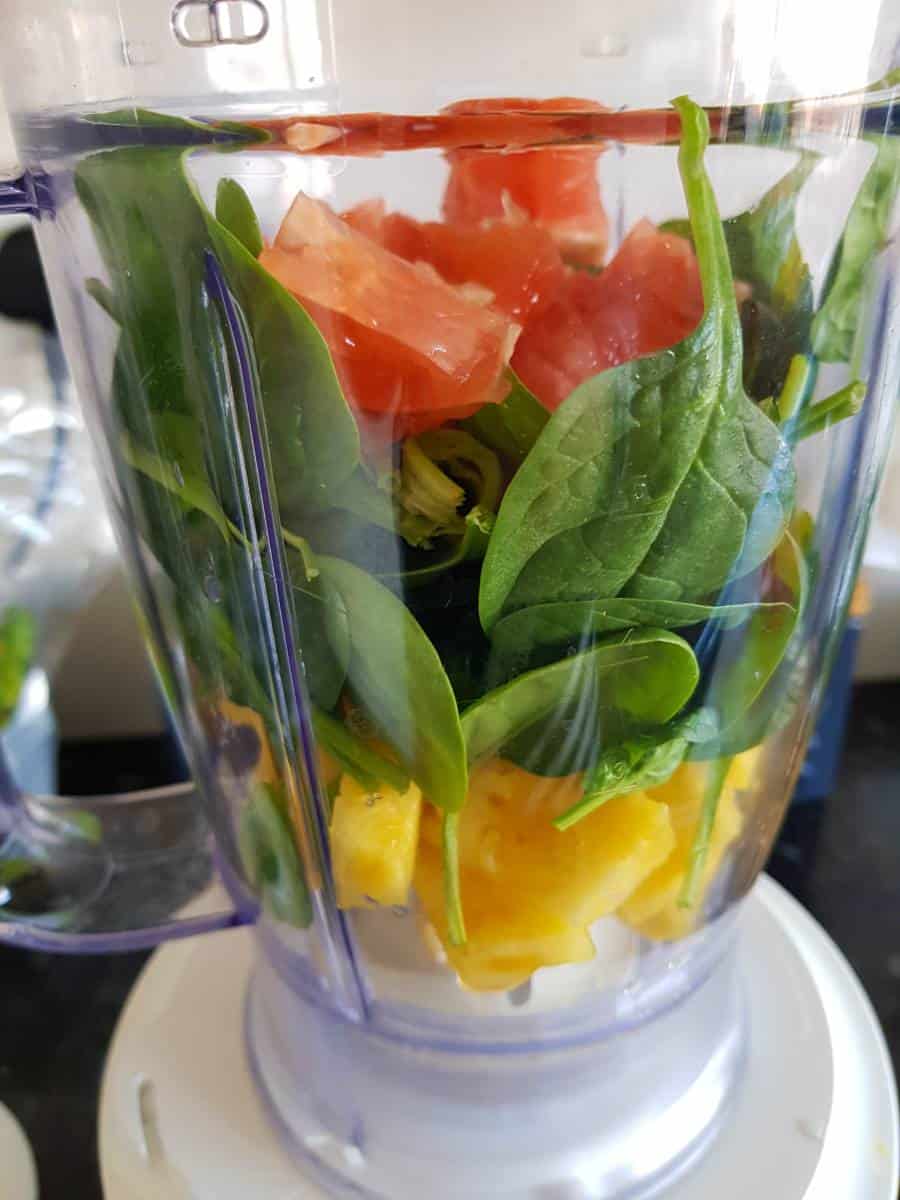 Spinach, pineapple and grapefruit in a blender.