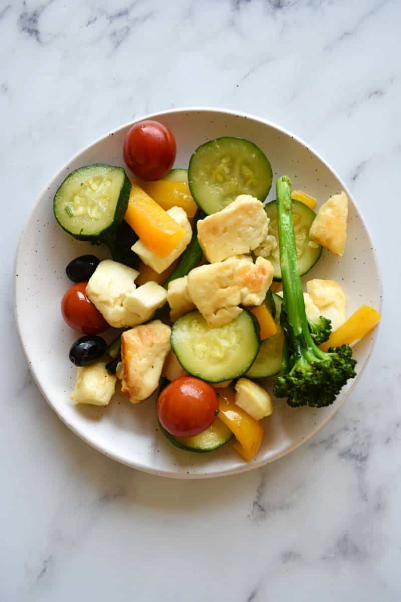 Stir fry with halloumi on a white plate.