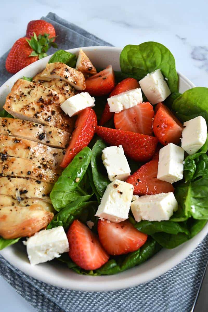 Strawberry salad with chicken in a bowl.