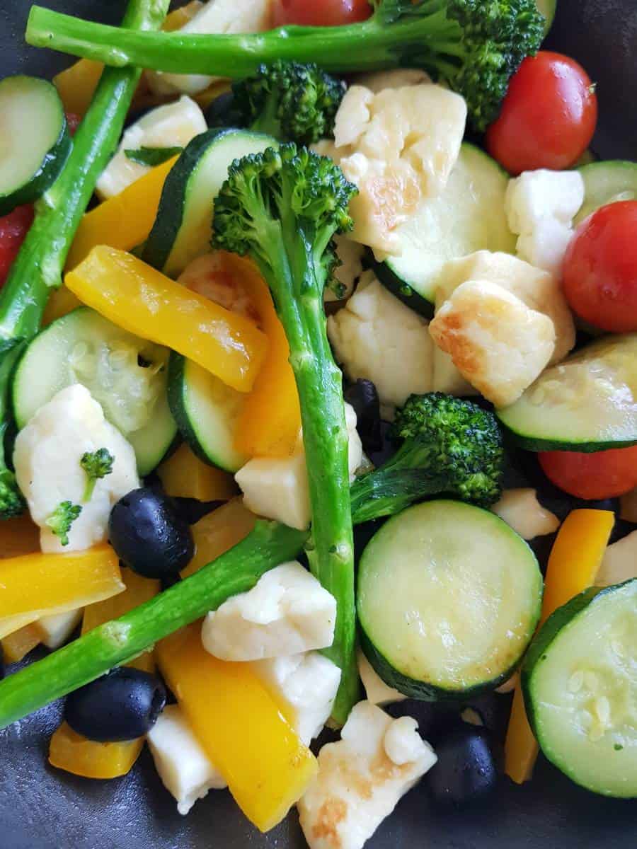 Halloumi and vegetables in a frying pan.