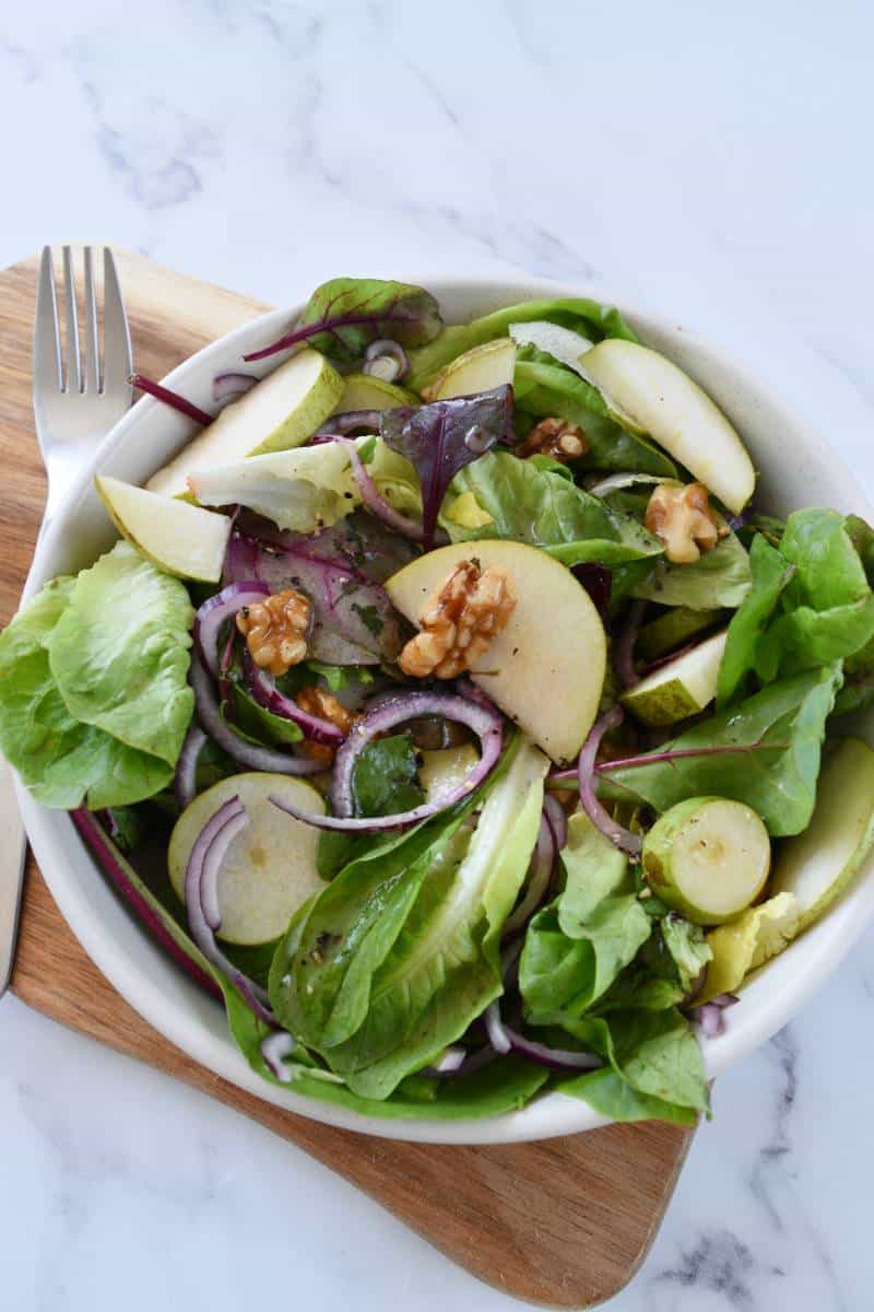 Walnut and pear salad on a wooden board.