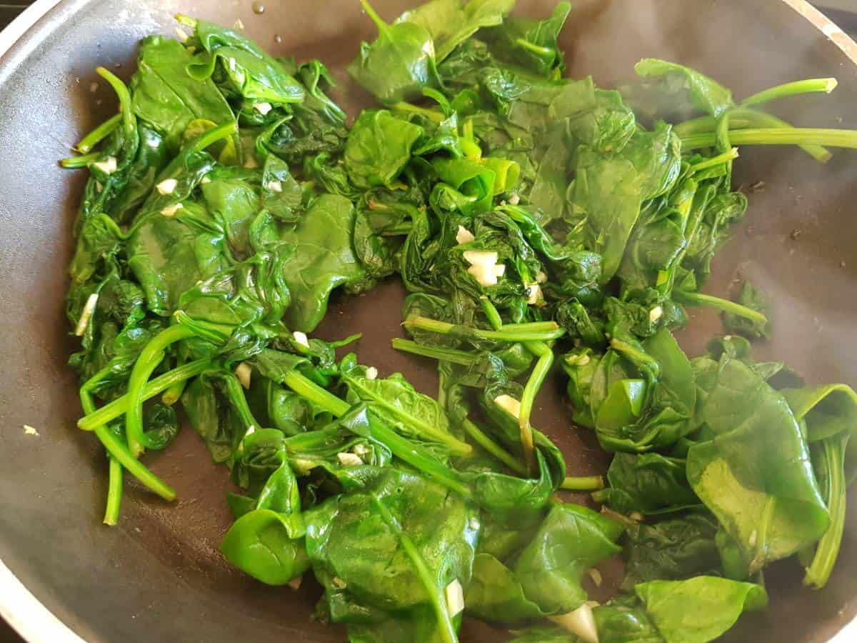 Wilted spinach in a frying pan.