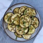 Za'atar roasted eggplant slices served on a plate with fresh herb garnish.