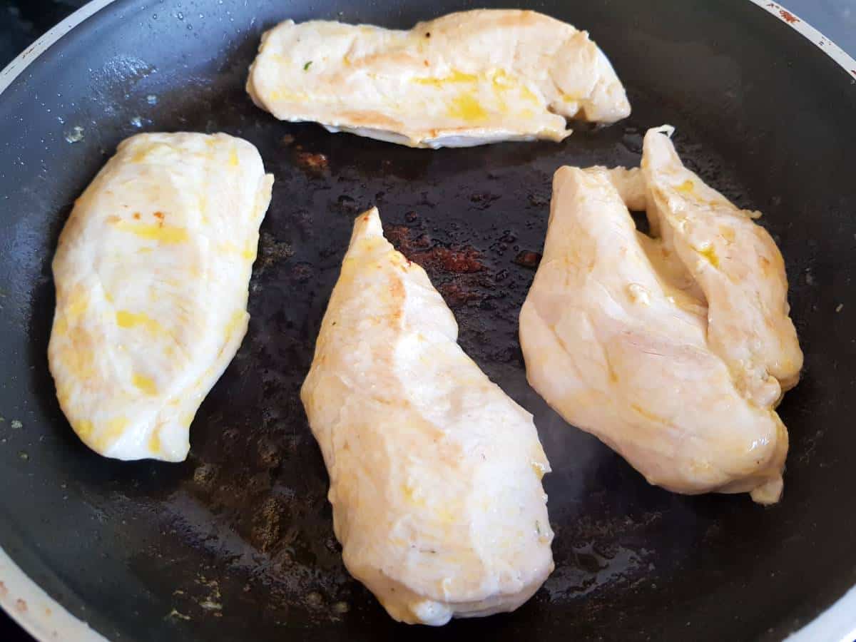 Chicken fillets in a pan.