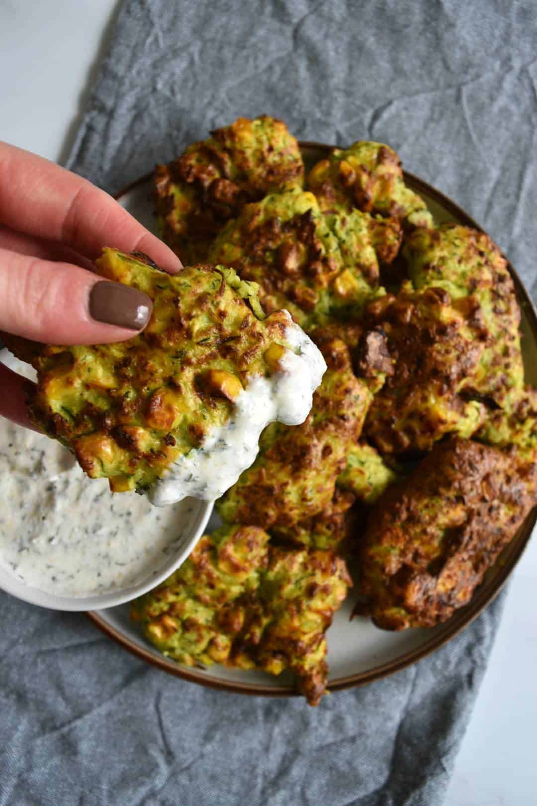 Air fryer fritters with zucchini and corn with ranch dressing on the side.