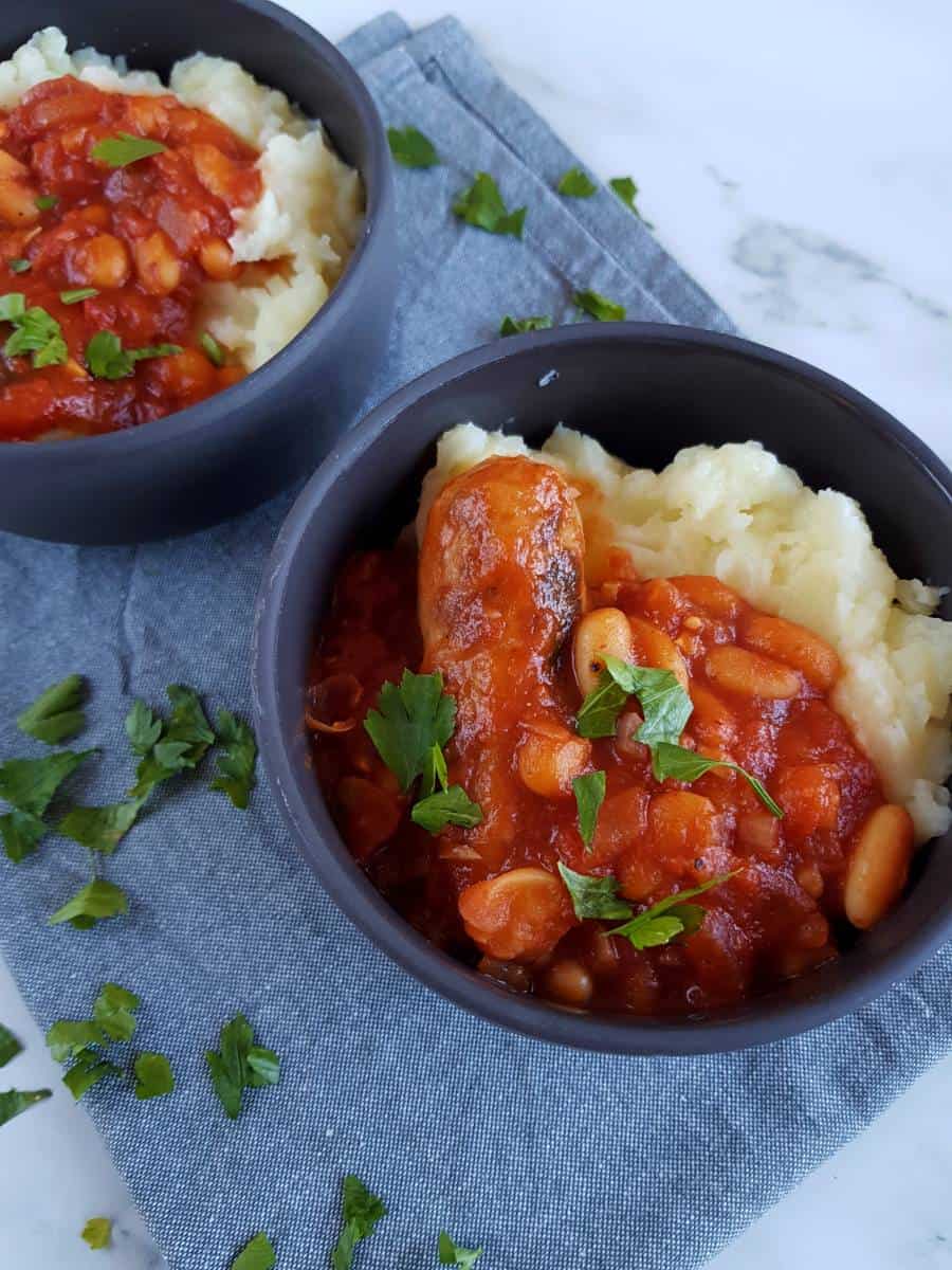 Bean and sausage stew in gray bowls.