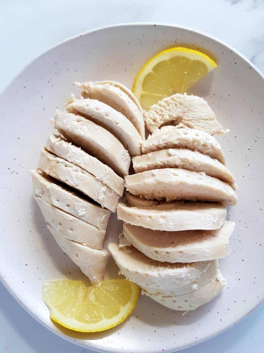 Boiled chicken breast fillets on a plate.