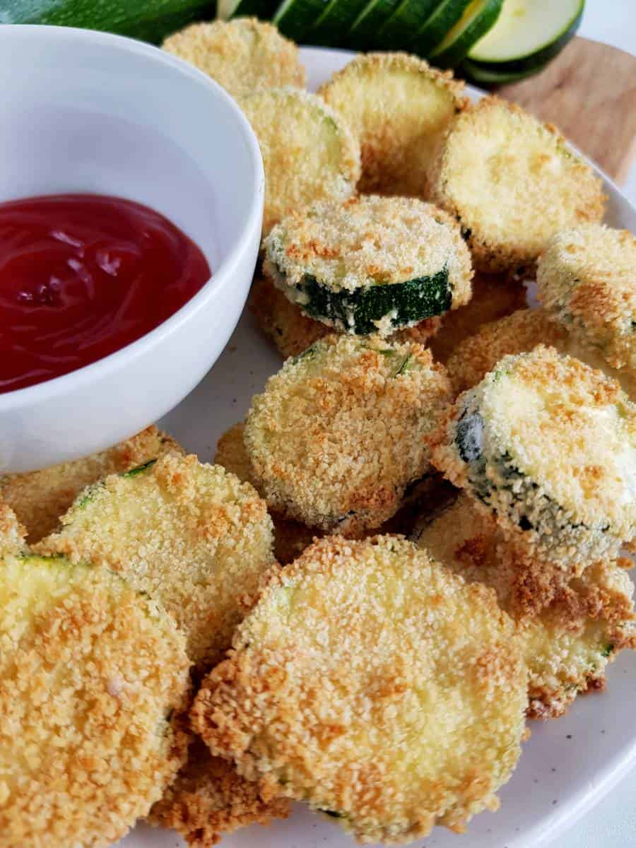 Breaded zucchini on a plate with dip.