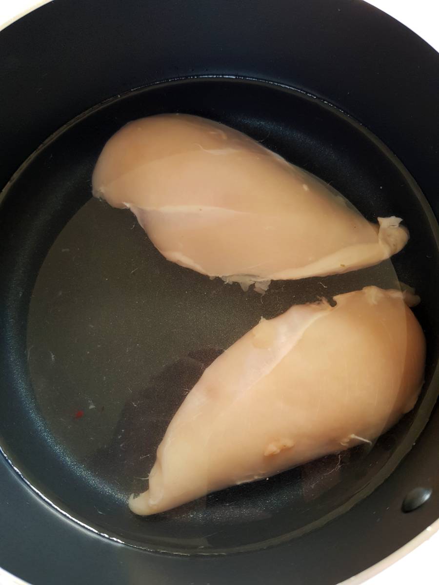 Chicken in water in a pot.