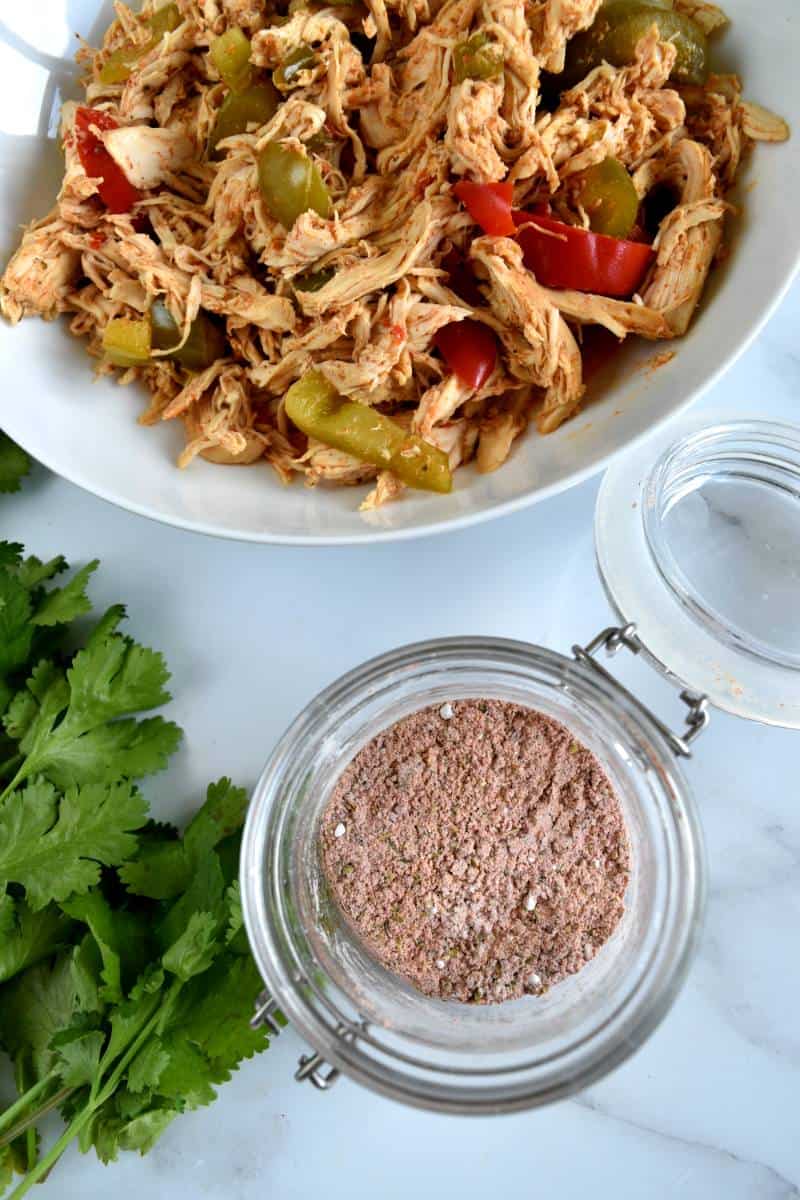 Fajitas with seasoning with chicken fajitas in the background.