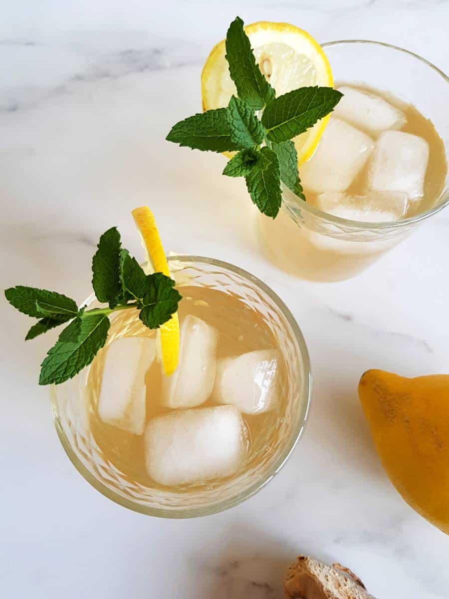 Ginger lemon iced tea in glasses with mint and lemon slices.