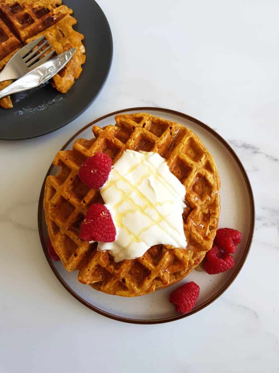 Golden butternut squash waffles on a plate.