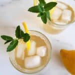 Lemon ginger iced tea in glasses with ice cubes, mint and lemon.