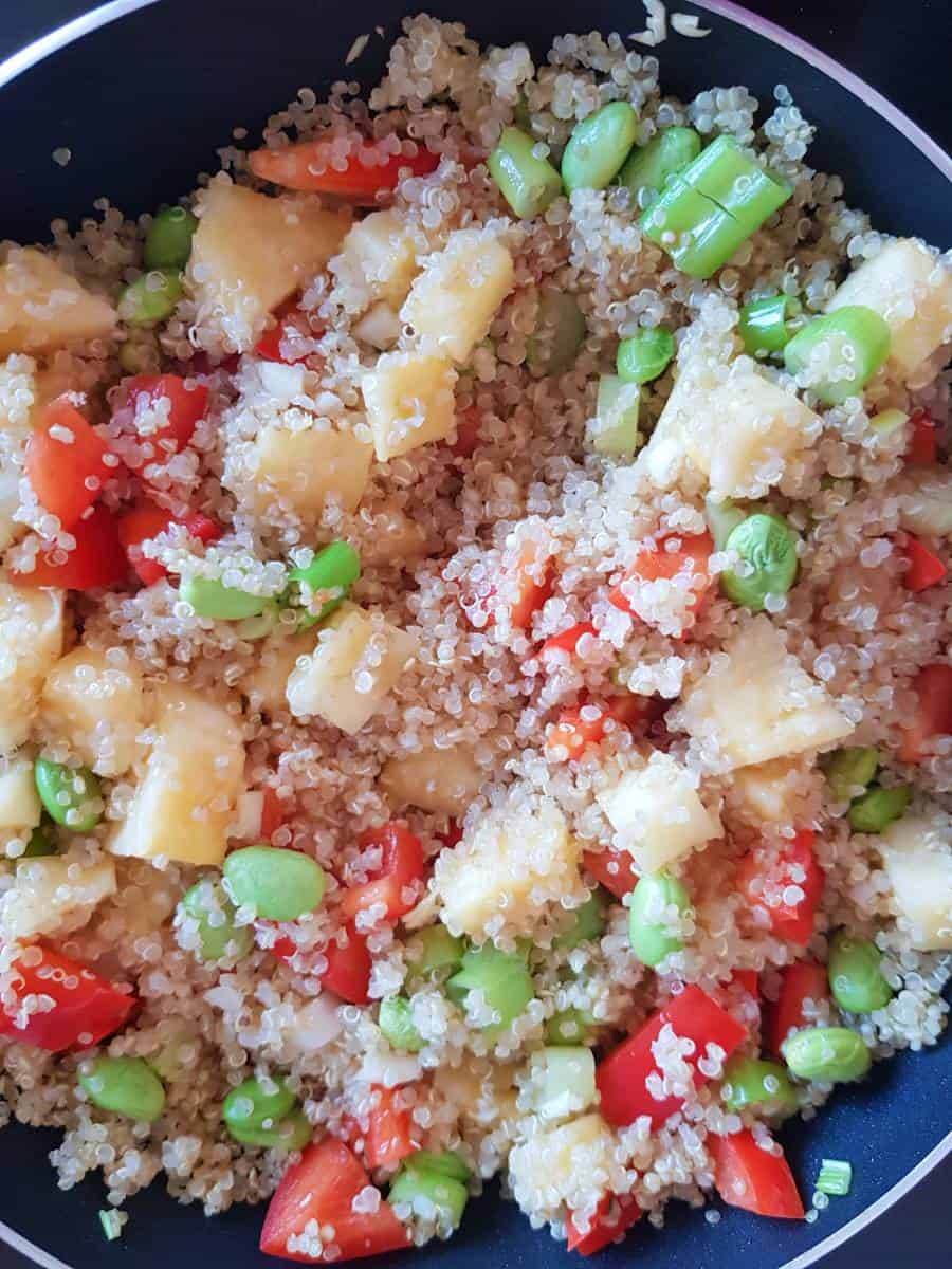 Making pineapple fried quinoa in a skillet.