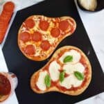 Naan bread pizzas on a baking sheet.