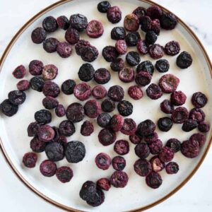 Oven dried blueberries on a plate.