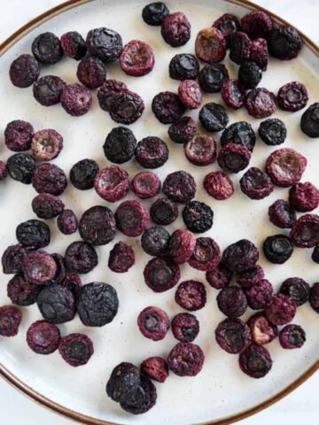 Oven dried blueberries on a plate.