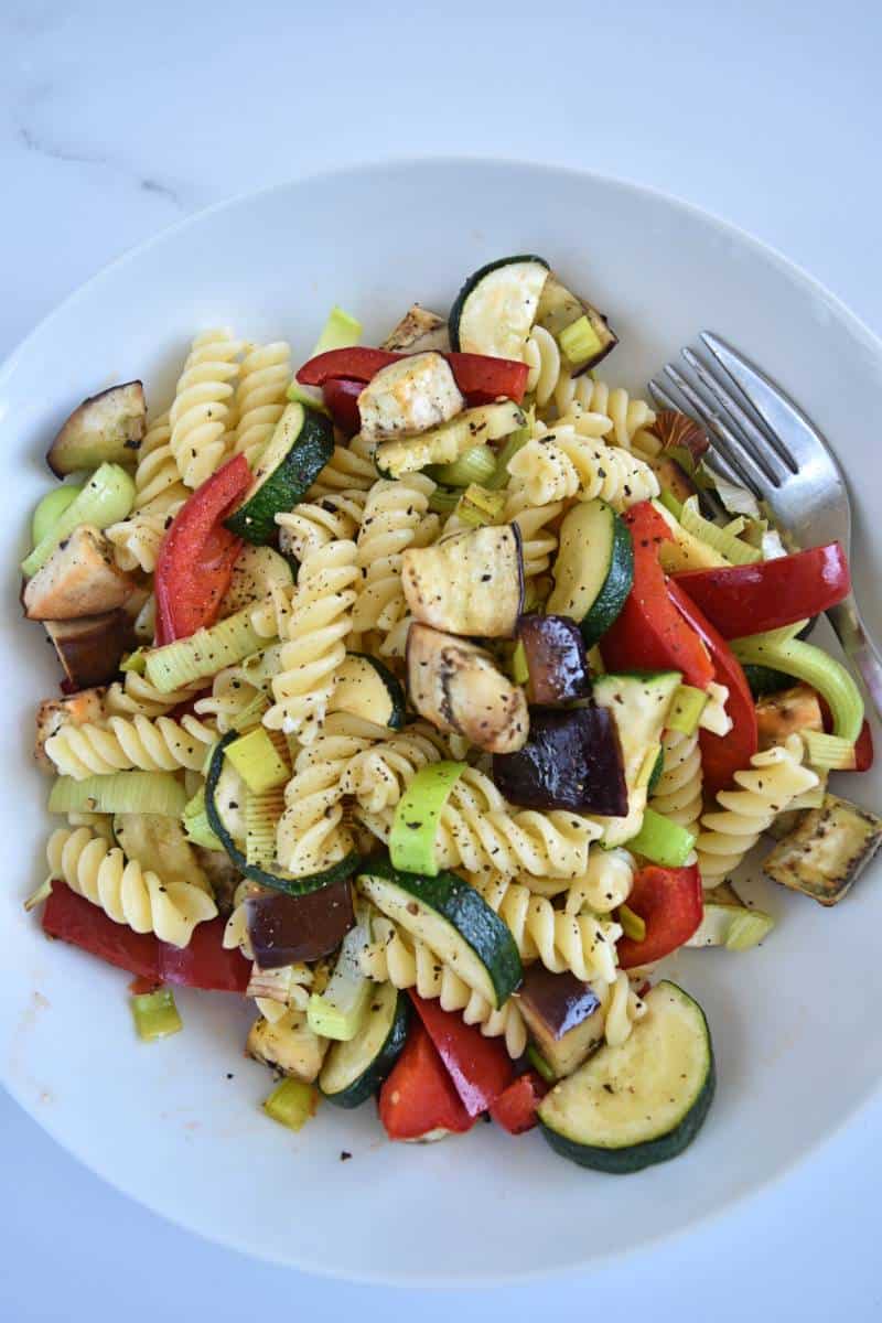 Pasta salad with roasted vegetables in a bowl.