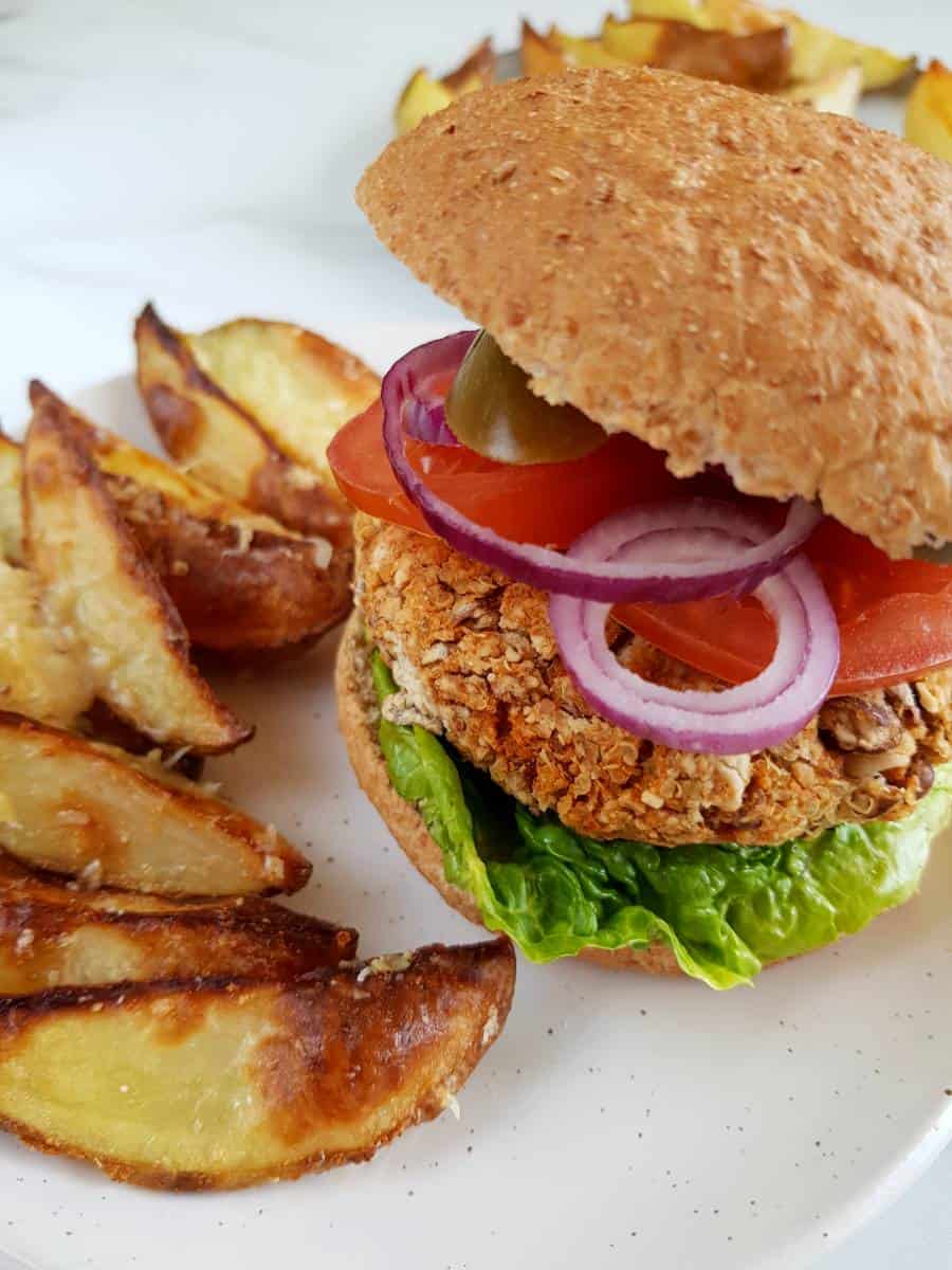 Pinto bean burger and potato wedges on a plate.