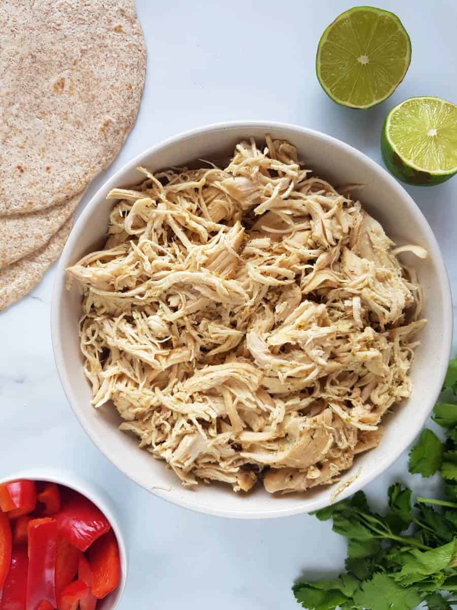 Pulled mojo chicken breasts in a bowl.